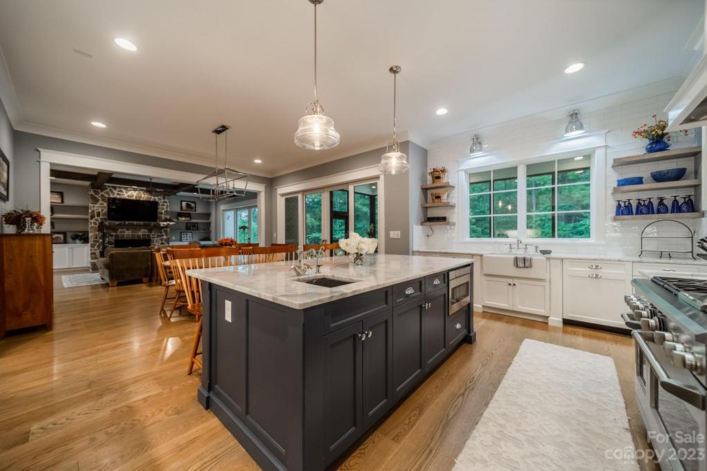 Kitchen into breakfast nook with telescoping doors leading to screened-in porch