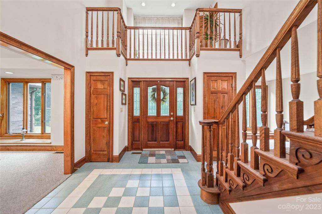 View of Front door and Entryway with balcony and 2 coat closets