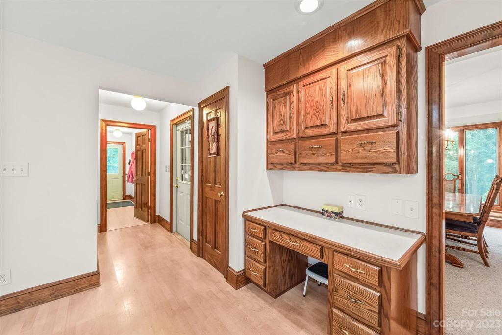 Computer niche in kitchen and view of hallway leading to garage and laundry/mud room