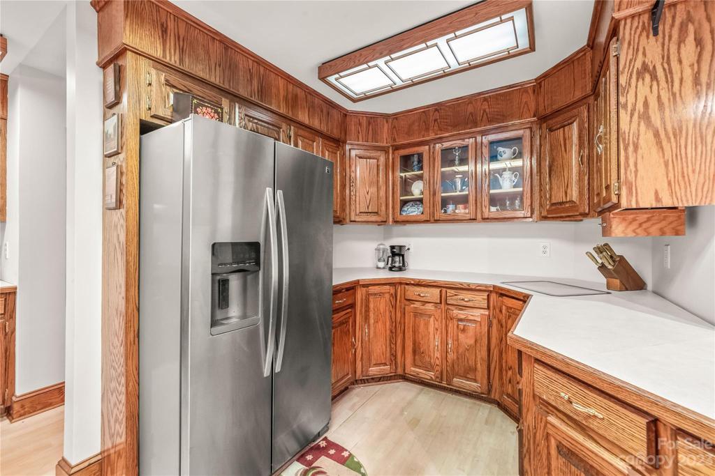 Stainless Steel refridgerator and lots of cabinets for storage including glass cabinets for display