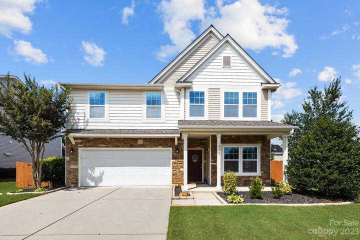 Meticulously maintained exterior showcases a blend of brick and siding, complemented by lush landscaping and a neatly manicured lawn.