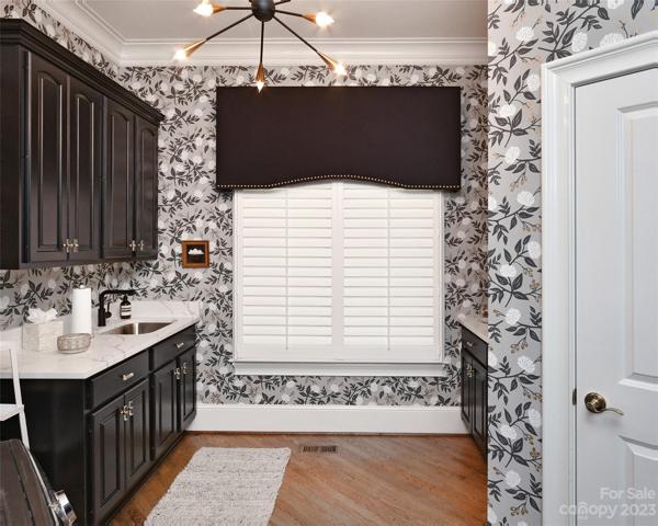 LAUNDRY ROOM: with additional pantry closet. Floral wall paper & updated modern light fixture. Custom cornice window treatment.