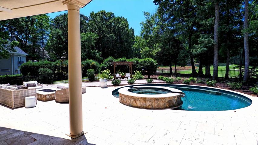 Travertine PATIO featuring: an outdoor  gas fire pit, BOCCE court and pergola with slate floor sitting area.
