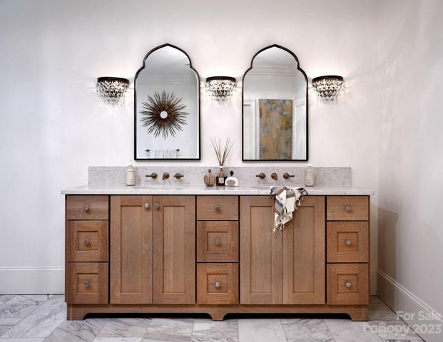 12"x25" marble tile, quartz countertops and raw wood cabinets. Champagne finished wall mounted faucets by Kohler®.
