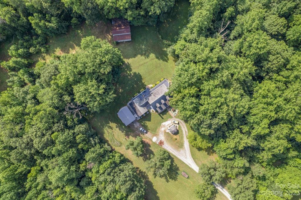 View of home with circular driveway, large carport and barn