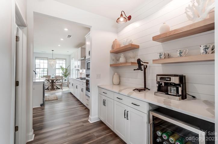 Custom Butler's pantry with custom white oak shelves and upgraded lighting and beverage fridge