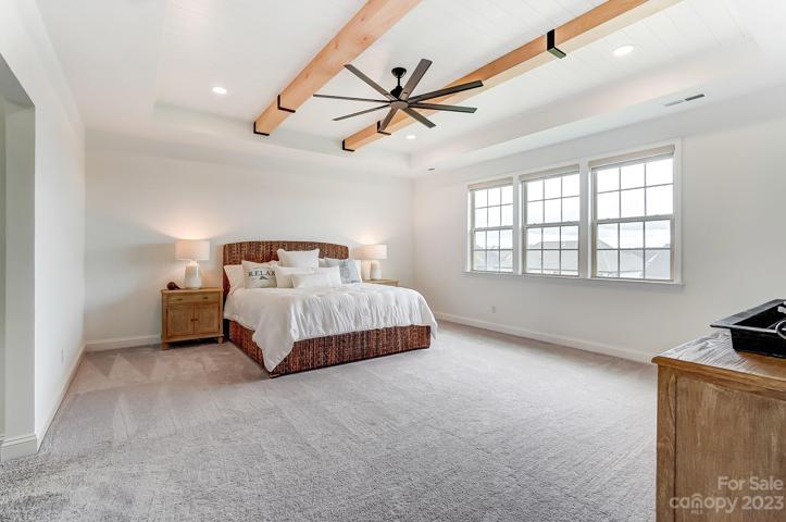 Stunning Primary bedroom with custom white oak beams and upgraded fan