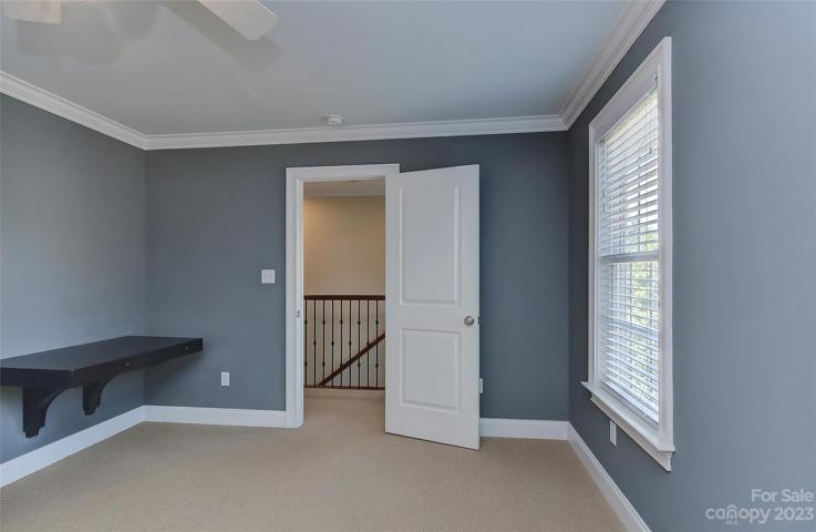 Bedroom 4 upstairs with ceiling fan w/light, crown molding, upgraded carpet, 2 inch blinds on windows and built in work station.