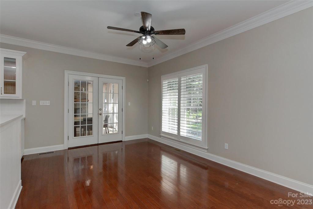 Open & casual dining room w/ceiling fan w/light, planation shutters on windows, crown molding, french doors opening to screened in porch and open to kitchen.