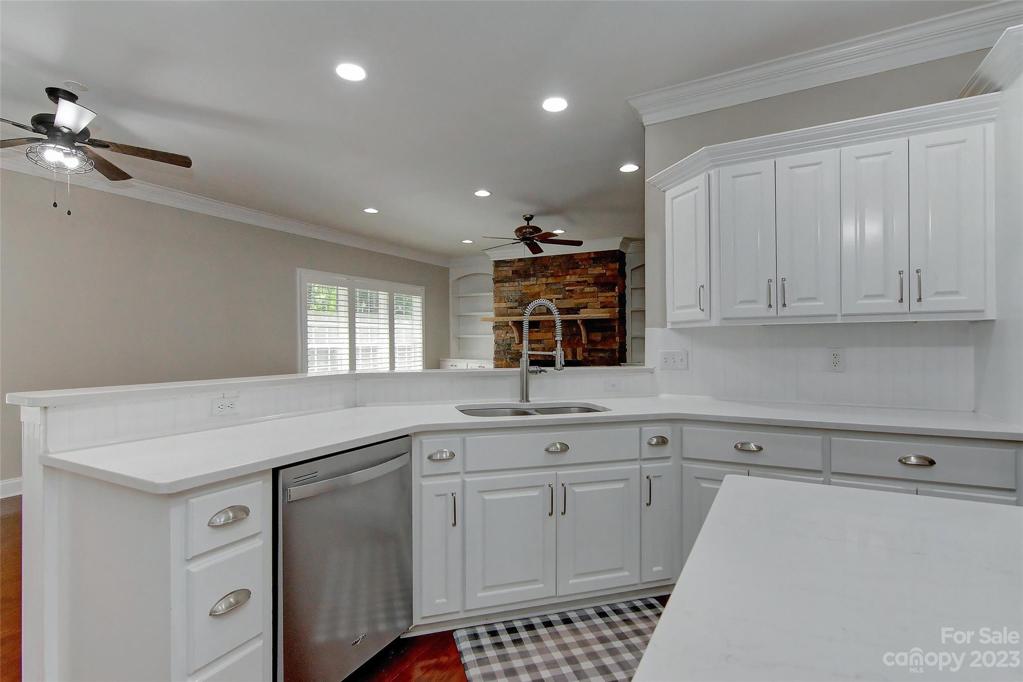 Open & cozy view from kitchen into dining & family room showing off the modern new kitchen faucet/sprayer.
