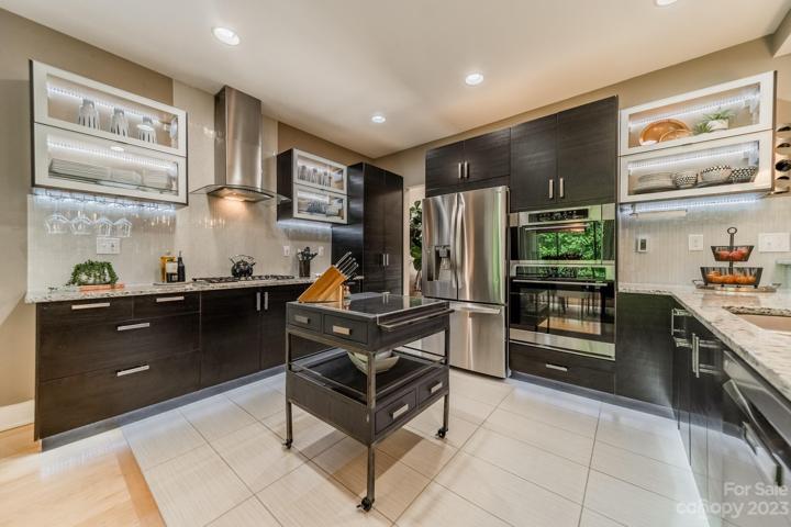 Modern kitchen features gas range and SS appliances