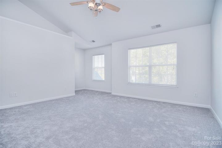 The vaulted ceiling and large windows enhance the size of this primary.