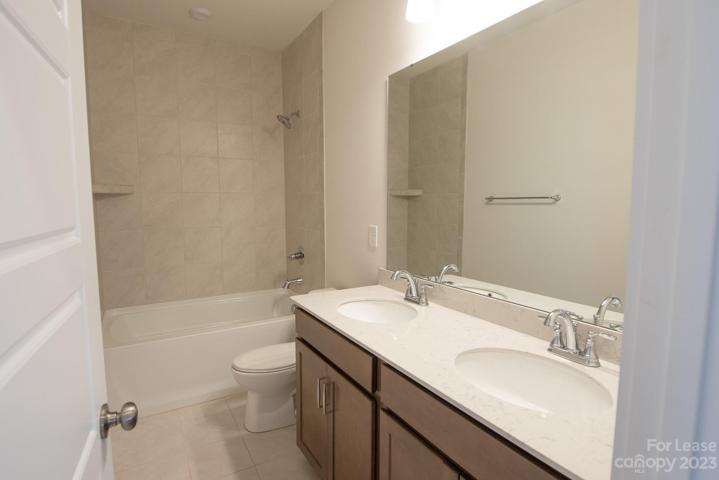 Guest bath w/ double sinks and tile surround shower