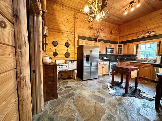 Large open Kitchen with beautiful stone floors, stainless appliances and oak cabinets.