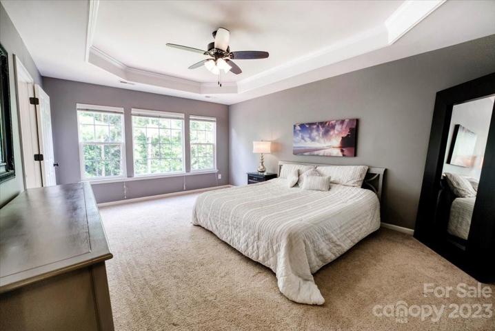 large primary bedroom with lots of natural light and overlooks a private wooded lot