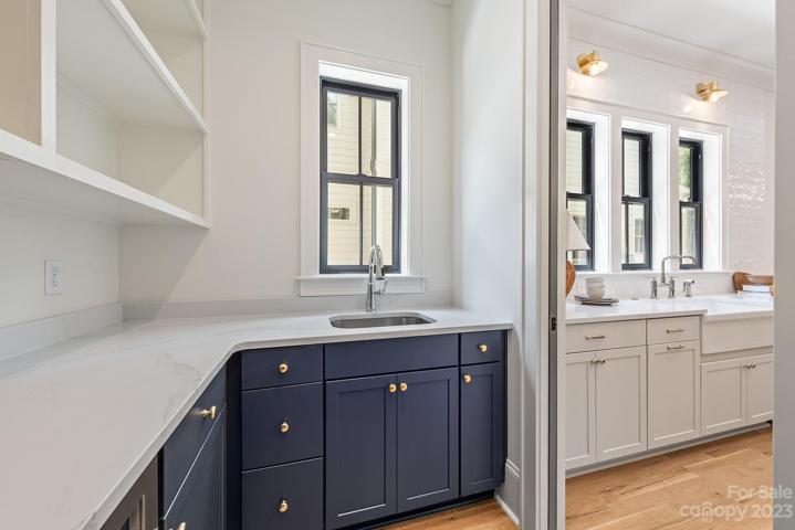 Large working pantry with quartz countertops, wine fridge and microwave