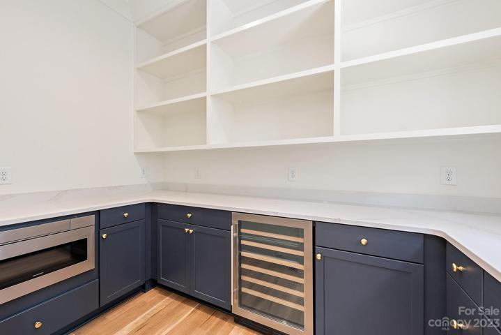 Large working pantry with quartz countertops, wine fridge and microwave
