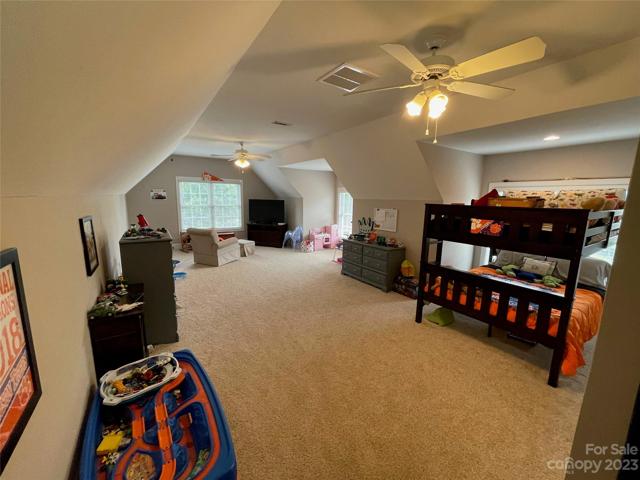 Bonus / Bedroom 4 upstairs.  This space is amazing and spans the entire length of the 3-car garage.  2 doormer windows and double windows on front of the home for plenty of light!  Double ceiling fans, carpet and walk-in closet... Space is being used currently as a playroom and bedroom.