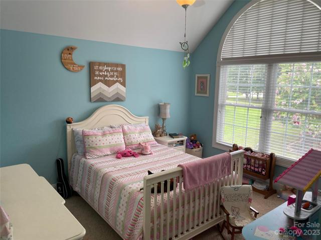 Bedroom 3 upstairs with vaulted ceiling, palladium window and ceiling fan.