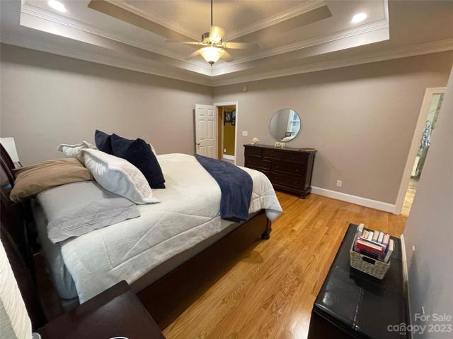 Primary bedroom on main level view to hallway and master ensuite.