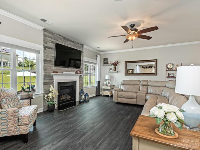 1st Flr - Living Room w/gas log FP, custom stone FP, in-ceiling speakers w/controller, windows look out to backyard/entertainment space