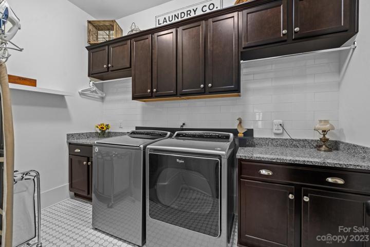 Large laundry room with plenty of cabinet and shelf space.