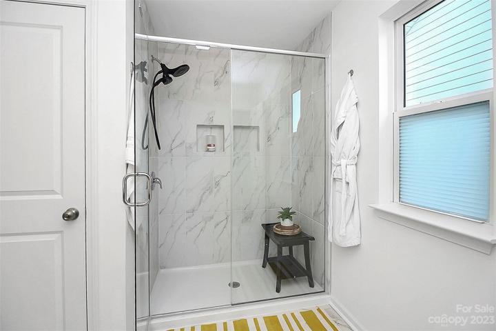 Well appointed primary bath with walk in shower, water closet, tile floors & shower walls.