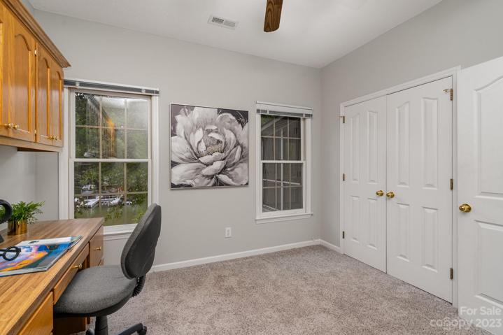 Secondary main-level room with built-in cabinetry, perfect for home office needs.