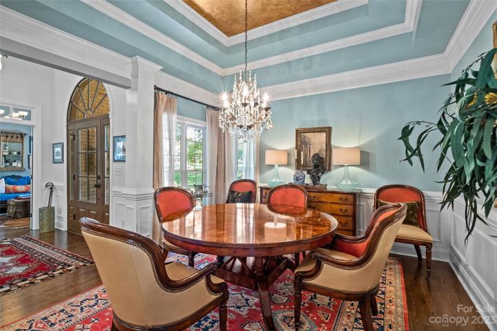 Dining Room on main level, tray ceiling, floor to ceiling windows, wainscoting wall accents.
