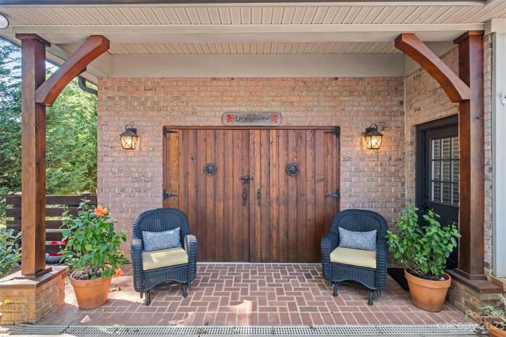 Bonus space added to the side of the existing garage outfitted with giant Cedar wood doors, heated and cooled inside. Measures 352 sq ft.