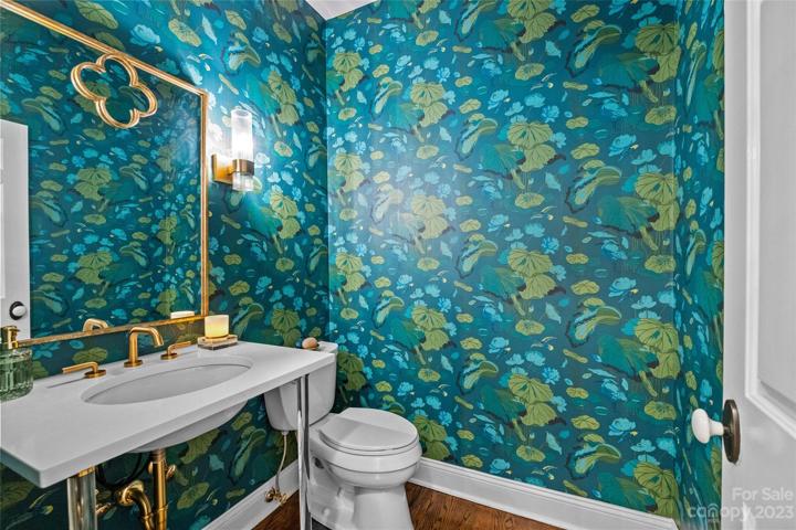 Renovated powder room, outfitted in G.P. Baker signature wallpaper of England, Kohler sink with Mountain Plumbing gold hardware, Riobel faucet and Palmer Industries polish brass un-lacquered sink with acrylic legs.  Crica lighting.