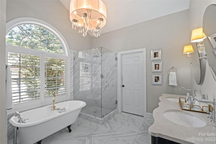 Primary bathroom, renovated in 2021.  Features Calacatta tile, a vintage cast iron tub, frameless shower, heated floors and Restoration Hardware double sink vanity and lighting.