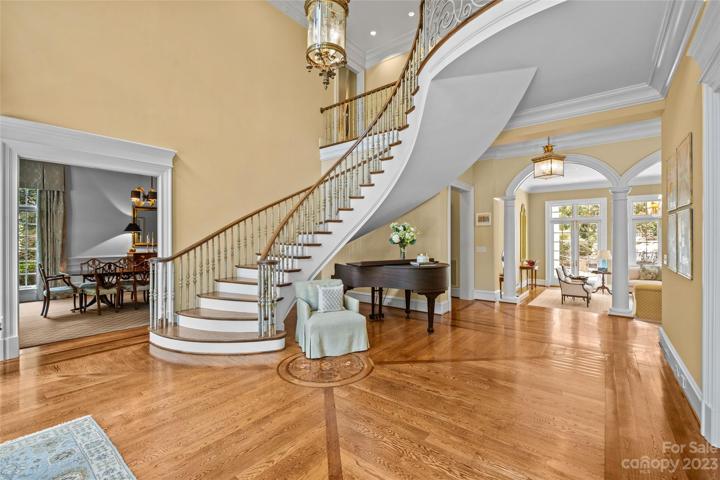 Enter the home to an opulent two-story foyer with 21' ceilings, floating curved staircase.