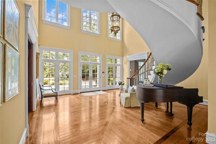 Enter the home to an opulent two-story foyer with 21' ceilings, floating curved staircase.