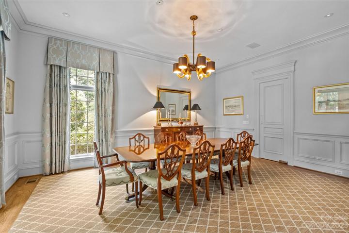 Elegant dining room with designer lighting & wood trim throughout.