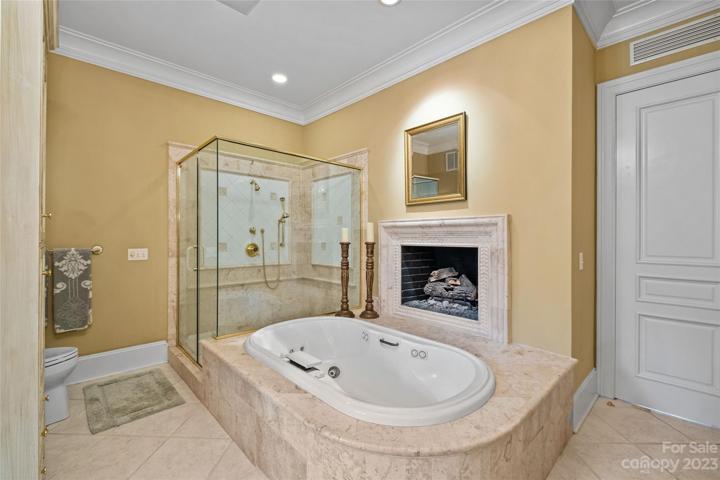 Stunning primary suite with his & her bathrooms, heated floors, walk-in closets & covered balcony overlooking the incredible resort pool & private backyard.