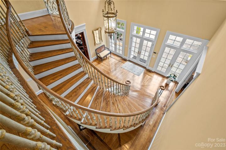 Opulent two-story foyer with 21' ceilings, floating curved staircase leads you to the upper level.
