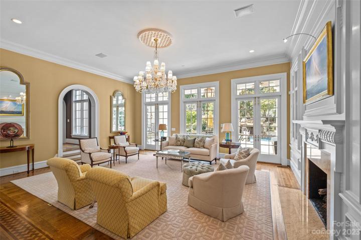 Elegant dining room with 12.5' ceilings, gas fireplace overlooking resort pool & lush backyard.
