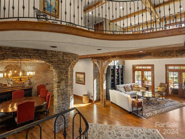 Photo taken from landing at stairwell, looking across foyer/hallway to living room, and to the left the dining room. You can see the vaulted ceiling in living room, with beams.