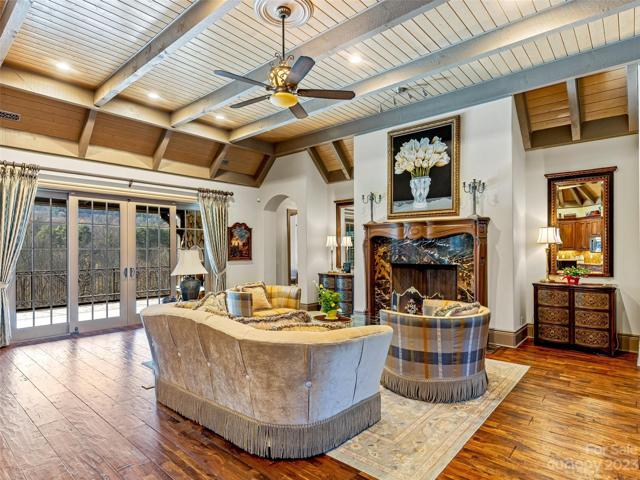 Voila! The Grand Hall features 13' timber ceilings with wood beams, a spectacular fireplace with a hand carved mantel encompassing a marble surround, and stunningly distressed European hardwood flooring.