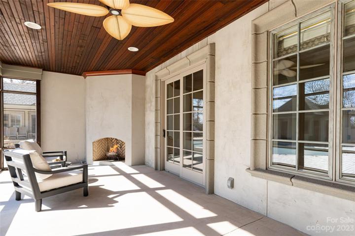 Covered screened porch with fireplace off of the primary bedroom