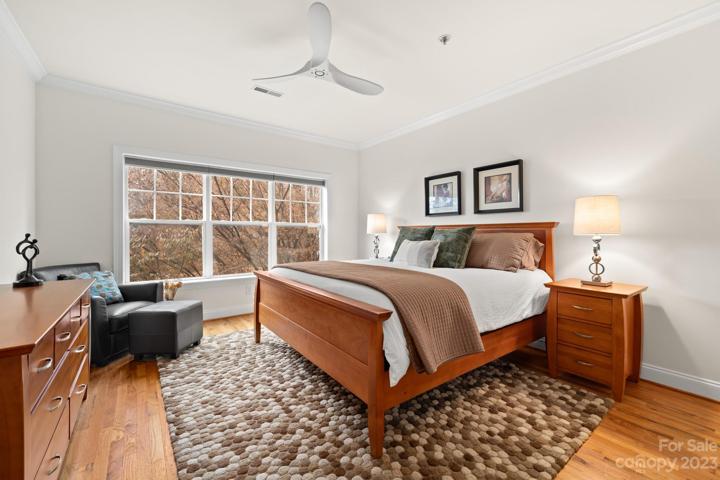 Large Primary Bedroom with large windows, updated fixtures and beautiful bedroom suite, chair and ottoman.