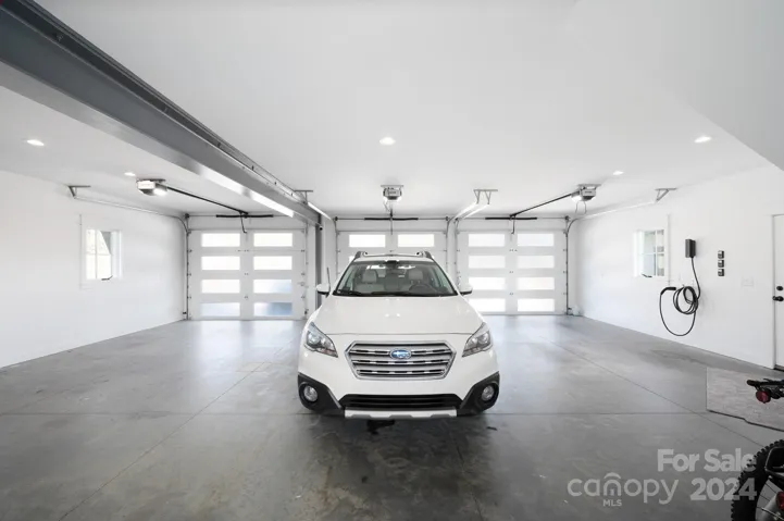 Three Car Garage with Frosted Glass Doors and Steel Beams Construction EV Charging Station with Wiring to Add Additional Chargers