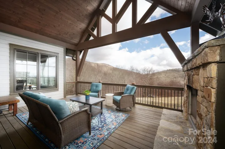 Covered Deck with Stacked Stone Fireplace and Cathedral Ceiling