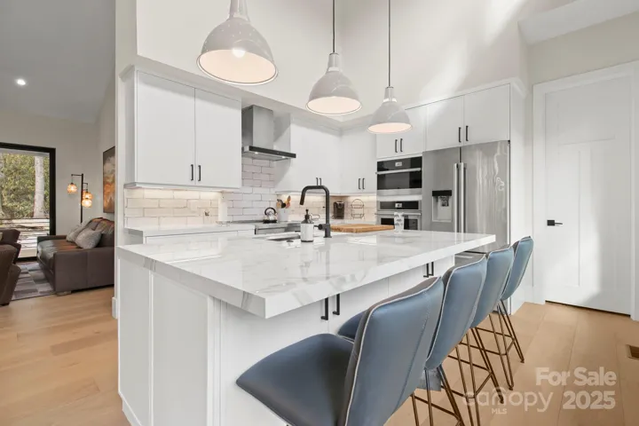 Spacious kitchen with high ceilings, large windows, and upscale appliances