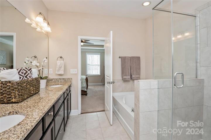 Primary bath has tiled shower and garden tub