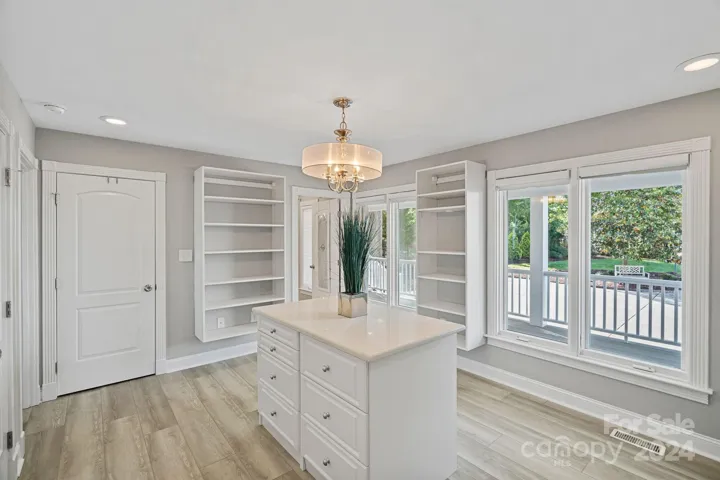 Primary closet with tons of storage and even an island. Bright with natural light.