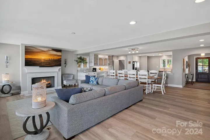 Open living room with fireplace, leads right into the kitchen.