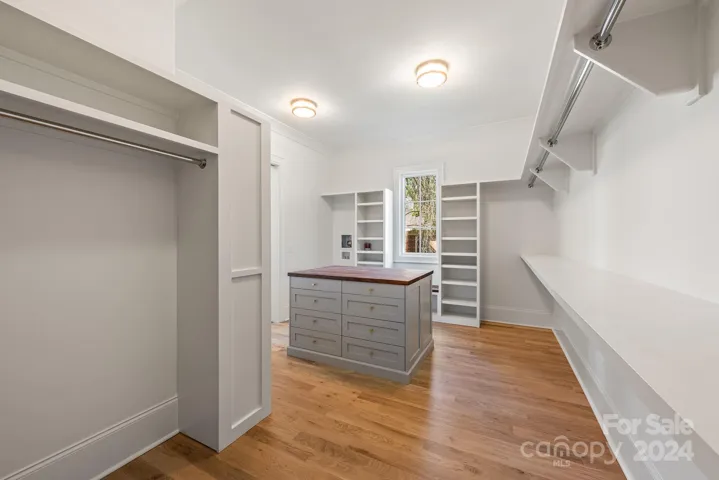 Primary closet features custom shelving and a washer/dryer hookups