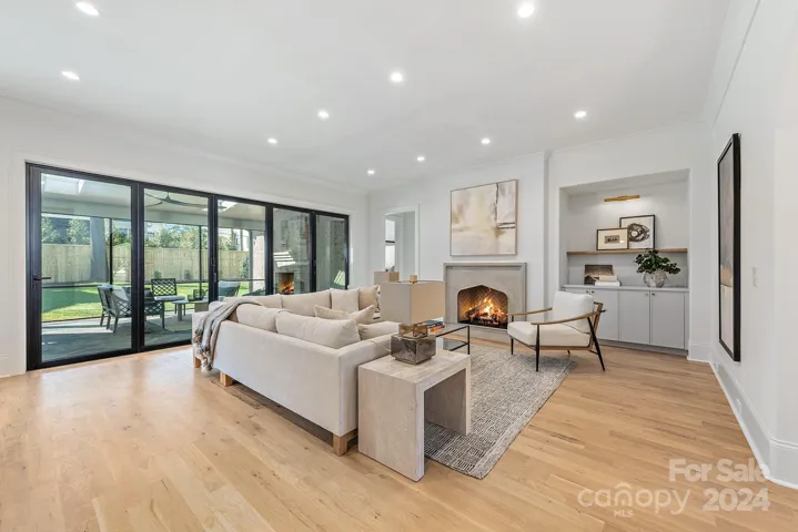 Open family room with accordion folding glass doors and Isokern fireplace.  Primary bedroom is to the left of the fireplace.